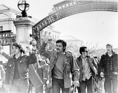Black and white photo of people marching at Sather Gate
