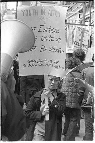 Person picketing with sign saying Youth in Action, Fight Evictions